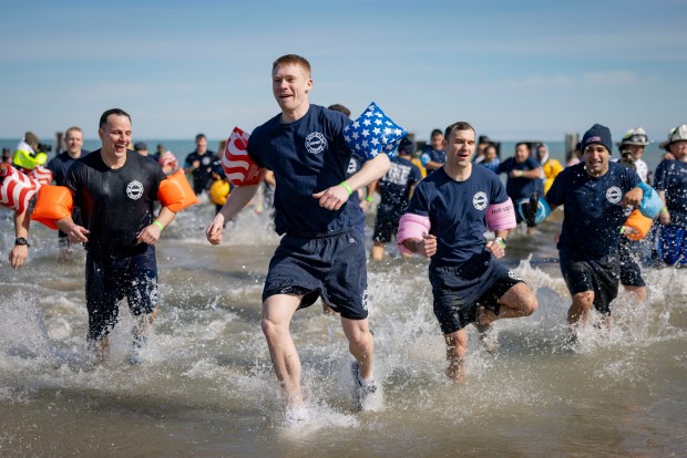 Chicago Fire Department members splash into Lake Michigan with temperatures in the 20s during the annual Polar Plunge benefitting Special Olympics Illinois. (Brian Cassella/Chicago Tribune)