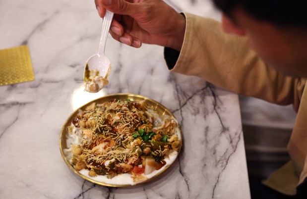 A customer digs into a plate of chana chaat in the early morning hours at Cafe Bethak in Lombard on March 16, 2025. Some customers were partaking in suhoor, the predawn meal before daylong fasting during Ramadan. (Chris Sweda/Chicago Tribune)