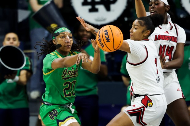 Notre Dame Fighting Irish forward Liatu King (20) passes while guarded by Louisville Cardinals forward Nyla Harris (2) during the first quarter at Purcell Pavilion in South Bend on Sunday, March 2, 2025. (Eileen T. Meslar/Chicago Tribune)