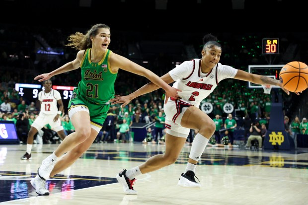 Notre Dame Fighting Irish forward Maddy Westbeld (21) and Louisville Cardinals forward Nyla Harris (2) scramble for a loose ball during the first quarter at Purcell Pavilion in South Bend on Sunday, March 2, 2025. (Eileen T. Meslar/Chicago Tribune)