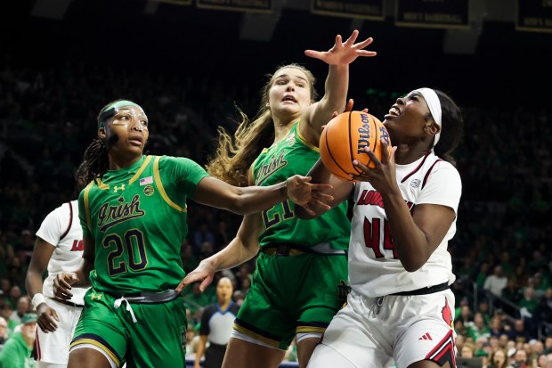 Notre Dame Fighting Irish forward Liatu King (20) and Notre Dame Fighting Irish forward Maddy Westbeld (21) try to block Louisville Cardinals forward Olivia Cochran (44) during the first quarter at Purcell Pavilion in South Bend on Sunday, March 2, 2025. (Eileen T. Meslar/Chicago Tribune)