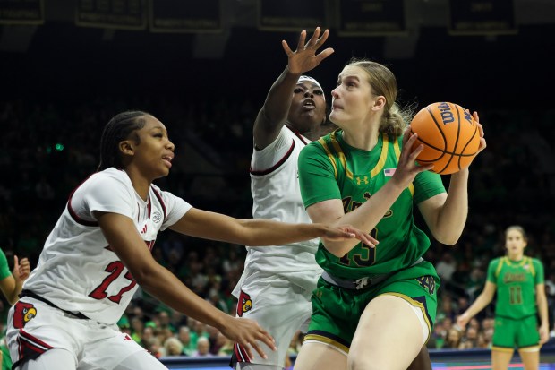 Louisville Cardinals guard Tajianna Roberts (22) and forward Olivia Cochran (44) try to block Notre Dame Fighting Irish forward Kate Koval (13) during the third quarter at Purcell Pavilion in South Bend on Sunday, March 2, 2025. (Eileen T. Meslar/Chicago Tribune)