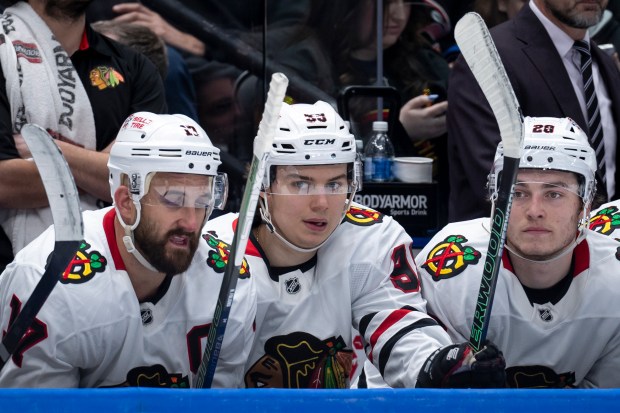 Chicago Blackhawks' Connor Bedard (98) sits on the bench with Nick Foligno (17) and Colton Dach (28) during the second period of an NHL hockey game against the Vancouver Canucks in Vancouver, British Columbia, Saturday, March 15, 2025. (Ethan Cairns/The Canadian Press via AP)