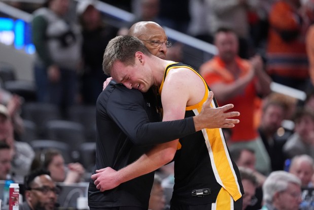 Iowa assistant coach Sherman Dillard hugs Iowa forward Payton Sandfort after the Hawkeyes' 106-94 loss to Illinois in the second round of the Big Ten Tournament on March 13, 2025, in Indianapolis. (Michael Conroy/AP)