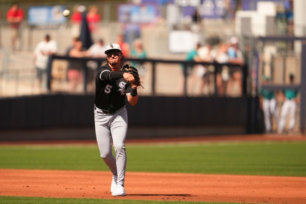 Chicago White Sox third baseman Josh Rojas throws to first base for the out against Seattle Mariners' Luke Raley during the second inning of a spring training baseball game Saturday, March 1, 2025, in Peoria, Ariz. (AP Photo/Lindsey Wasson)