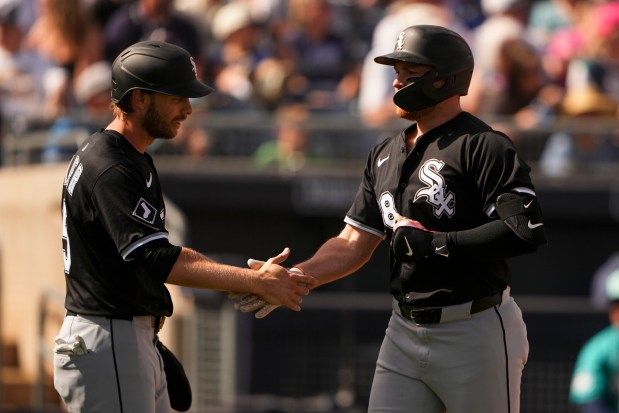 Chicago White Sox's Brandon Drury, right, is greeted by teammate Austin Slater, left, after hitting a three-run home run against the Seattle Mariners during the third inning of a spring training baseball game Saturday, March 1, 2025, in Peoria, Ariz. (AP Photo/Lindsey Wasson)