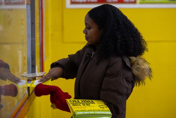 Aliyah Collins, Blacks in Green's sustainable square mile manager, hands out flyers for a community event in Chicago on Feb. 14, 2025. (Audrey Richardson/Chicago Tribune)