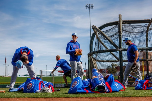 Cubs manager Craig Counsell walks past players while the field is prepared for live batting practice during spring training at Sloan Park on Feb. 19, 2025, in Mesa, Ariz. (Armando L. Sanchez/Chicago Tribune)