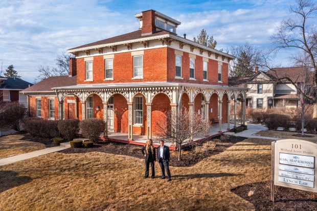 Bridget Salela, left, and Walt Burrell, cofounders of The Ville Team of Coldwell Banker Realty, are seen outside Naperville's historic Willard Scott House at 101 N. Washington St. The Ville Team has purchased the 158-year-old building for its new office. (Reel Tour Media)