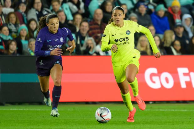 Orlando Pride defender Kerry Abello, left, and Washington Spirit forward Trinity Rodman chase after the ball during the NWSL championship game on Nov. 23, 2024, in Kansas City, Mo. (AP Photo/Reed Hoffmann)