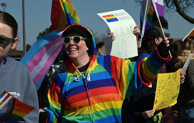 In rainbow colors along Lake Cook Road is Jen Houghton of Arlington Heights at the Rally for Love, Protest for Love event in Buffalo Grove on Saturday, March 8, 2025. (Karie Angell Luc/Pioneer Press)