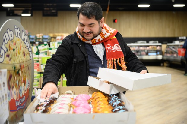 Hammond resident Nicholas Casas picks out paczki from a display at Carpathia Deli in Schererville as shoppers stock up on the pastries for Paczki Day on Tuesday, March 4, 2025. (Kyle Telechan/for the Post-Tribune)