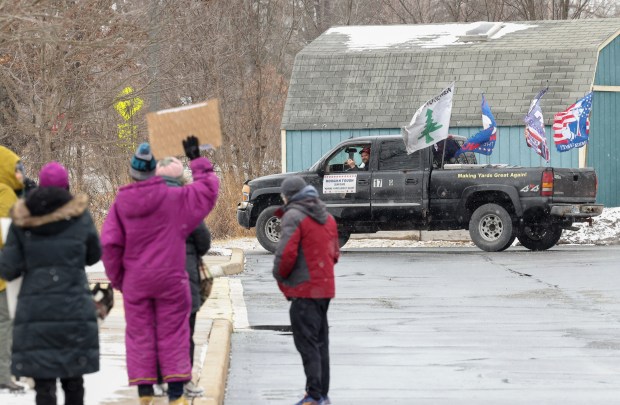 A Trump supporter advertising a lawn care service drives past demonstrators gathering to protest ongoing cuts to National Park Service staff at the start of a rally outside the Indiana Dunes Visitor Center Saturday, March 1, 2025, in Porter, Indiana. (John J. Kim/Chicago Tribune)