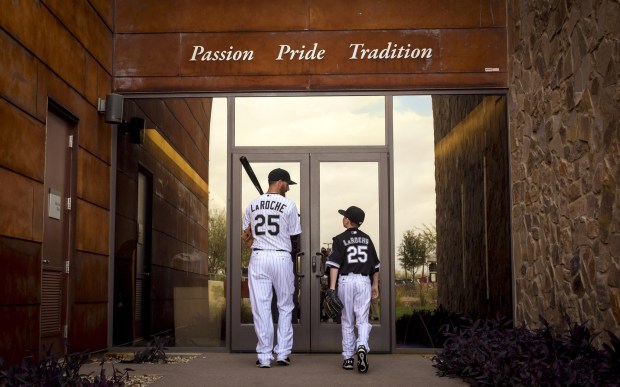 White Sox first baseman Adam LaRoche walks back into the clubhouse with his son Drake, 13, after spring training photo day on Feb. 28, 2015.