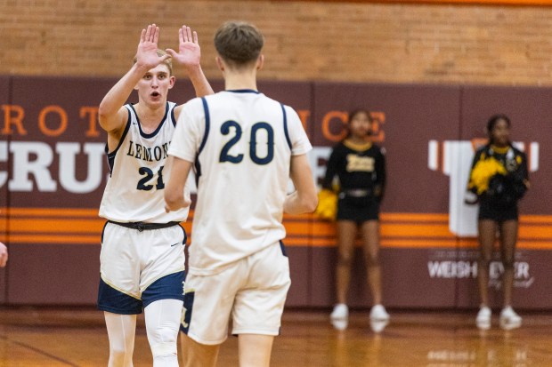 Lemont's Gabriel Sularski (21) goes to congratulate Matas Gaidukevicius (20) after his dunk against Marian Catholic during the Class 3A Brother Rice Sectional semifinals in Chicago on Wednesday, March 5, 2025. (Vincent D. Johnson / for the Daily Southtown)