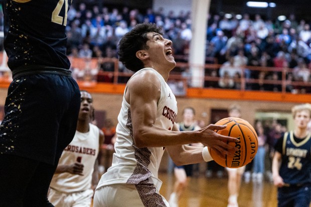 Brother Rice's Marcos Gonzales slips by a leaping Lemont's Gabriel Sularski (21) during the Class 3A Brother Rice Sectional final in Chicago on Friday, March 7, 2025. (Vincent D. Johnson / for the Daily Southtown)