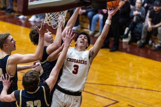 Brother Rice's Marcos Gonzales (3) scores on a layup as three Lemont defenders converge on him during the Class 3A Brother Rice Sectional final in Chicago on Friday, March 7, 2025. (Vincent D. Johnson / for the Daily Southtown)