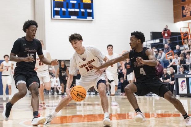 Brother Rice's Max Justic (15) spins around Peoria's Anthony Sturdivant || (4) during the Class 3A Pontiac Supersectional game on Monday March 10, 2025. (Troy Stolt for the Daily Southtown)