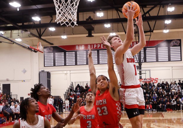 Marist's Rokas Zilys (1) lays up a shot over Rich Township's Nyshawn Turner (23) during a Class 4A Rich Township Sectional semifinal basketball game on Wednesday March 5, 2025.(John Smierciak / Daily Southtown)