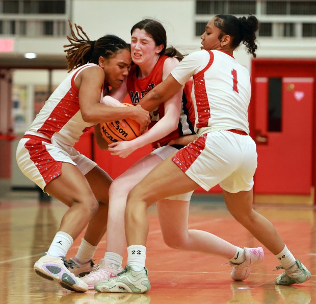 Marist's Lily Porter, center, Kenwood's Ariella Henigan, left, and Icesis Thomas, right, fight for the ball during the Class 4A Hinsdale Central Supersectional girls basketball game in Hinsdale on Monday, March 3, 2025. (James C. Svehla / for the Daily Southtown)