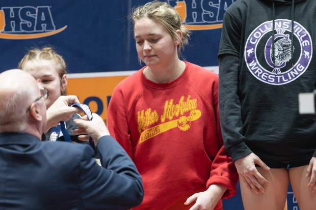 Mother McAuley's Maggie Zuber receives a second place medal in the 135 pound weight class of the IHSA girls wrestling individual state meet on in Bloomington on Saturday, March 1, 2025. (Troy Stolt / for the Pioneer Press)