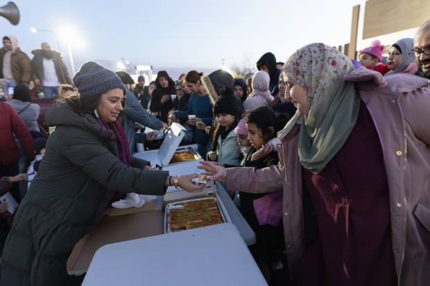 Leena Odeh, left, passes out pastries during a community Leena Odeh, left, passes out pastries during a community gathering at Al Manarah Square to celebrate the Bridgeview installing Ramadan and Eid lights on Harlem Avenue Feb. 28, 2025. (Troy Stolt/for the Daily Southtown)gathering at Al Manarah Square to celebrate the Village of Bridgeview installing Ramadan and Eid lights on Harlem Avenue on Friday, Feb. 28, 2025. (Troy Stolt / for the Daily Southtown)