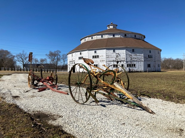 Historic farm equipment remains outside the Manhattan Round Barn in Will County, which will be lifted from its foundation this spring as part of a large rehab project. (Paul Eisenberg/Daily Southtown)