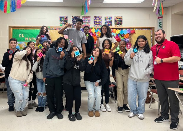 Foreign language teacher Jordan Oliva and the Spanish Honor Society he helped form pose during a craft day. (Jordan Oliva)