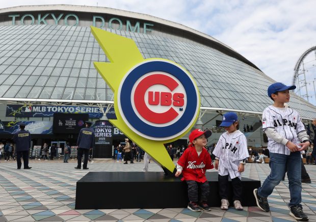 Children sit and stand near a Cubs logo outside the Tokyo Dome before both the Cubs and Dodgers work out in preparation for the Tokyo Series on March 14, 2025, in Tokyo. (John J. Kim/Chicago Tribune)