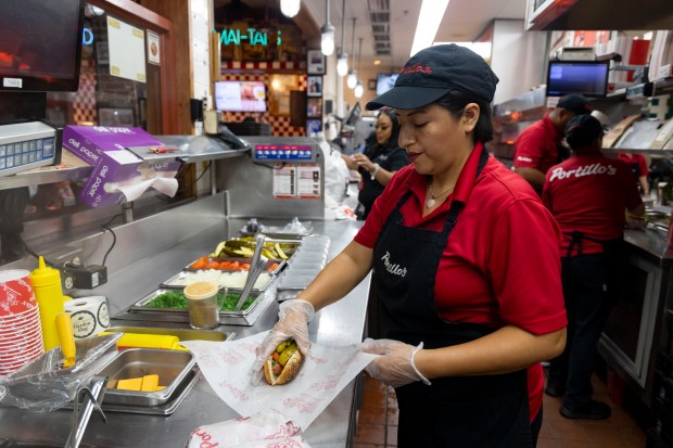 Lorena Gualan makes Chicago dogs at Portillo's on Tuesday, Sept. 24, 2024, in River North. (Brian Cassella/Chicago Tribune)