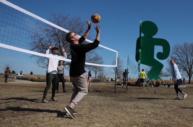 Friends play volleyball near Belmont Harbor on March 9, 2025. (Eileen T. Meslar/Chicago Tribune)