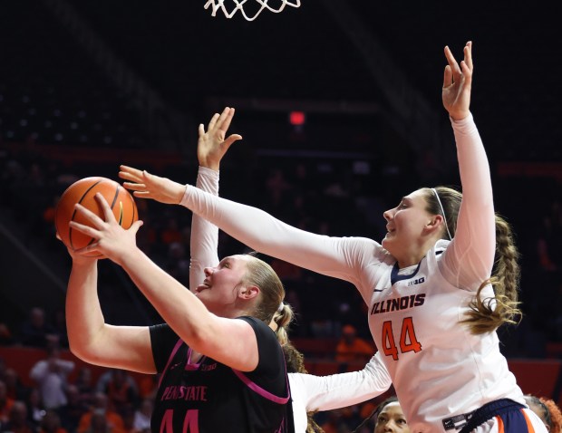 Illinois forward Kendall Bostic, right, reaches for a block against Penn State center Gracie Merkle on Feb. 13, 2025, at the State Farm Center in Champaign. (John J. Kim/Chicago Tribune)