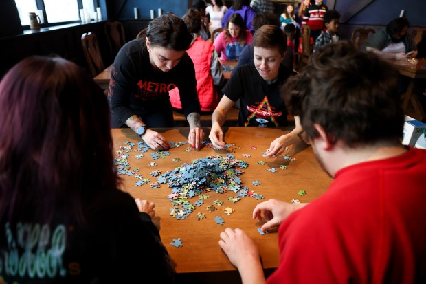 Babs Owca, left, and Haley Engle participate in a monthly puzzle race with their friends at Snakes & Lattes Chicago in Logan Square on March 9, 2025. (Eileen T. Meslar/Chicago Tribune)