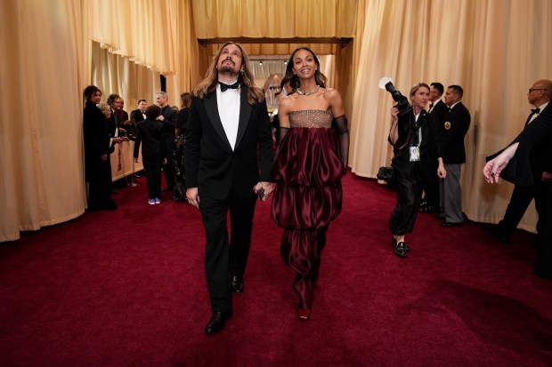 Marco Perego-Saldana, left, and Zoe Saldana arrive at the Oscars on March 2, 2025, at the Dolby Theatre in Los Angeles. (John Locher/AP)