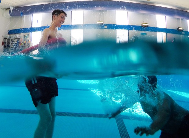 Braxton Farr, 24, left, plays in the water with his caregiver Kareem Stevenson at the YMCA in Elmhurst on Feb. 17, 2025. (Stacey Wescott/Chicago Tribune)