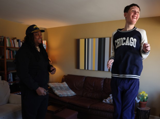 Braxton Farr, 24, jumps up and down with happiness with the arrival of caregiver Kareem Stevenson on Feb. 10, 2025 in Elmhurst. (Stacey Wescott/Chicago Tribune)