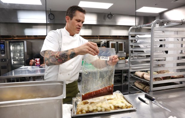 Devon Quinn, chief culinary officer with The Paramount Group, checks on a sous vide bag containing pear syrup infused with cannabis concentrate as he prepares a cannabis-infused dinner on April 17, 2025, for Sunday at Eden restaurant. (Chris Sweda/Chicago Tribune)