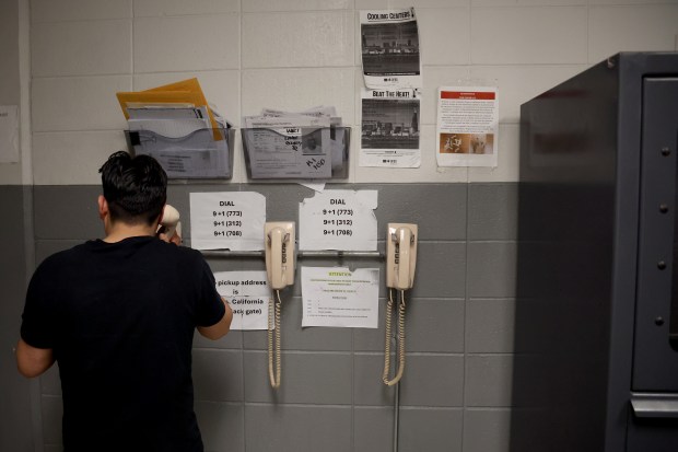 A detainee makes a phone call in a room used for fingerprinting and processing in an underground area at the Cook County Jail in Chicago on April 16, 2025. (Antonio Perez/Chicago Tribune)