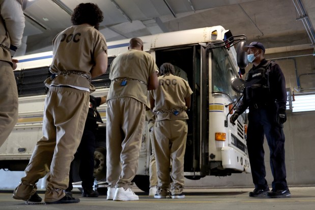 Under watch of Cook County officers, inmates cuffed at the wrists and ankles walk into a bus on April 16, 2025, for transportation to their court appearances in courthouses throughout Cook County. (Antonio Perez/Chicago Tribune)