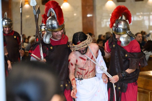 Congregants dressed as Roman soldiers flank Jesus, played by East Chicago resident Eron Herrejon, during the Our Lady of Guadalupe East Chicago's annual Way of the Cross procession on Good Friday, April 18, 2025. (Kyle Telechan/for the Post-Tribune)