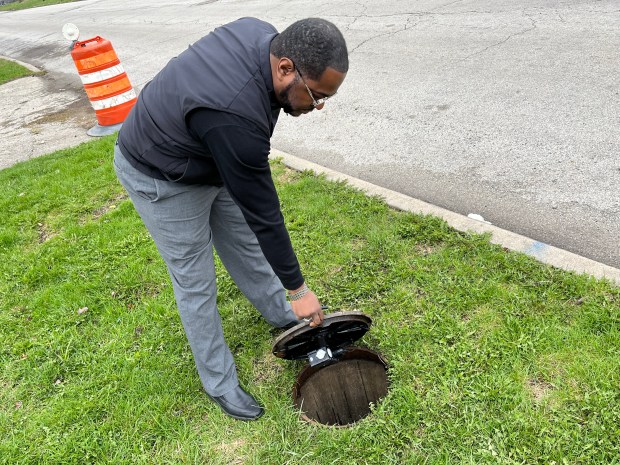 Pastor Johnathan Johnson opens the meter box housing the Holy Bible Missionary Baptist Church's water meter, which he said is turned off to prevent high water bills and only activated before Sunday services. (Samantha Moilanen/Daily Southtown)