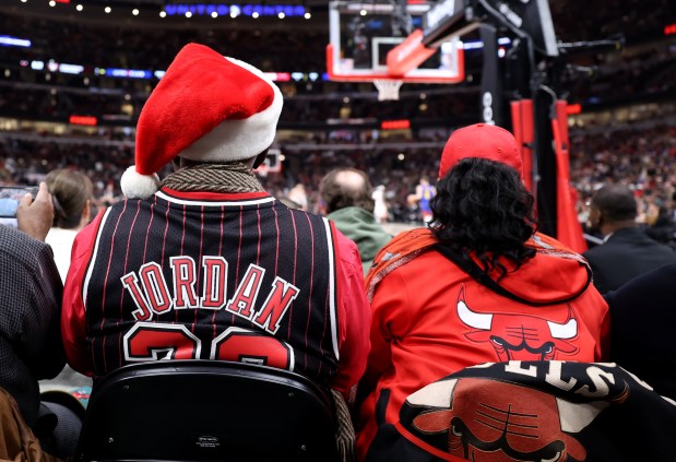 A Chicago Bulls fans wearing team apparel watches a game between the Bulls and the Denver Nuggets at the United Center on Dec. 12, 2023. (Chris Sweda/Chicago Tribune)