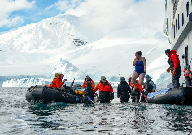 Caroline Eubanks jumps into the icy depths as part of a polar plunge, one of her favorite experiences during a trip to Antarctica. (Nathan Kelley/Lindblad)