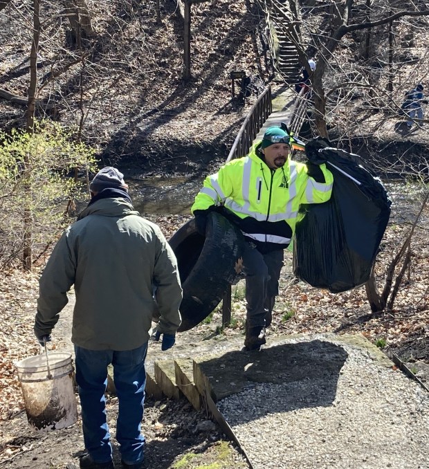 A volunteer brings bags from the riverbank. (Steve Sadin/For the Lake County News-Sun)