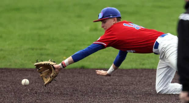 Marmion's Charlie Zebig (14) dives to grab a Fenwick grounder in the seventh inning during a Chicago Catholic Conference game in Aurora on Thursday, May 1, 2025.(H. Rick Bamman / The Beacon-News)