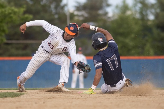 Oswego East's Jacsen Tucker (17) slides into second base beating the tag from Oswego's Kam Jenkins (25) during a Southwest Prairie Conference game in Oswego on Thursday, May 22, 2025. (Troy Stolt for the Beacon News)