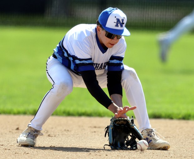 St. Charles North's Nolan Macholz (1) scoops up a grounder by St. Charles East's Matthew Steinberg in the first inning during a DuKane Conference game in St. Charles on Saturday, May 3, 2025.(H. Rick Bamman/for the Beacon-News)