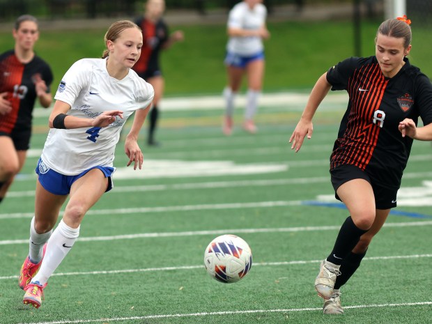 St. Charles North's Kaitlyn Nudera, left, and St. Charles East's Georgia Smith run down the ball during the Class 3A Glenbard West Sectional semifinal soccer game in Glen Ellyn on Tuesday, May 27, 2025.(James C. Svehla / for the Beacon-News)