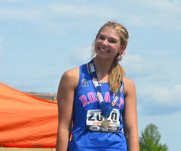 Rosary's Katie Kostro smiles on the medal stand after winning the Class 2A state championship in the high jump at Eastern Illinois in Charleston on Saturday, May 24, 2025. (Jeff Vorva / The Beacon-News)