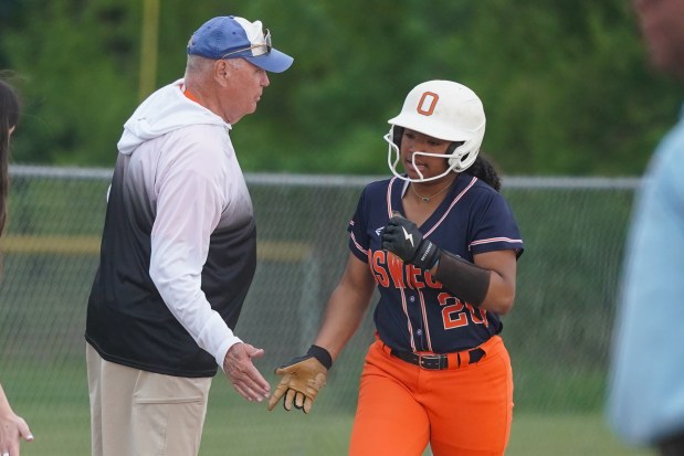 Oswego's Jaelynn Anthony (20) is greeted by head coach Paul Netzel at third after hitting a two run homer against Metea Valley during a Class 4A Oswego East Regional semifinal game at Oswego High School on Tuesday, May 27, 2025. (Sean King / for The Beacon-News)